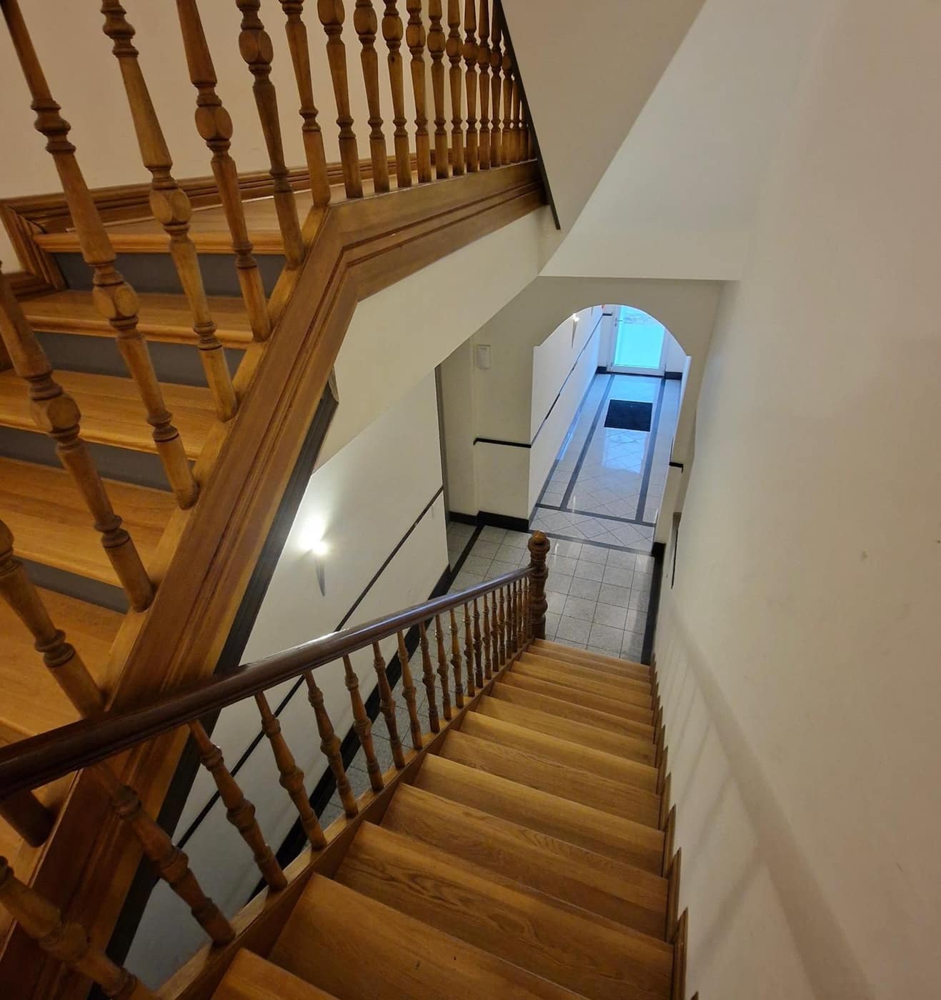 Gereinigtes Treppenhaus mit Holzgeländer und Blick zum Eingangsbereich